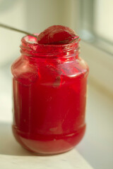 Jam in jar. Red berry in sugar. Jam in natural light. Glass jar with candied berries.