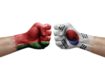 Two hands punch to each others on white background. Country flags painted fists, conflict crisis concept between belarus and south korea