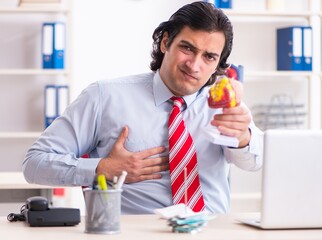 Young male employee suffering in the office