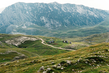 Fototapeta na wymiar Road near a small settlement in a mountain valley