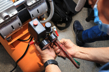 Close-up of a technician fixing a compressor