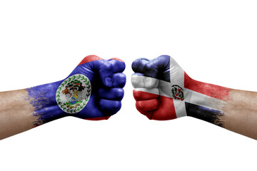 Two hands punch to each others on white background. Country flags painted fists, conflict crisis concept between belize and dominican republic