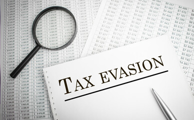 Paper with Tax evasion on a table. Tax concept