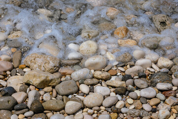 Pebbles on a Ionian coast in Agios Gordios resort village on Corfu Island, Greece