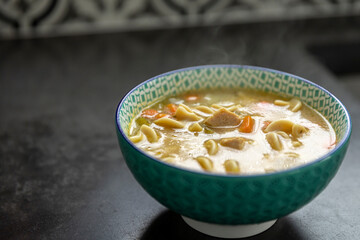 chicken noodle soup in a green bowl.