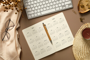 Home office desk table, elegant feminine workspace. Weekly planner calendar with pen, keyboard,...