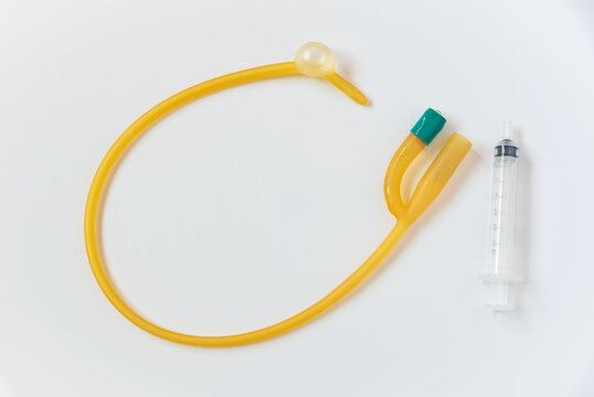 Foley catheter and syringe on white background - a yellow tube and a sy in a white background