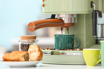 Preparing fresh espresso with coffee machine on table in kitchen