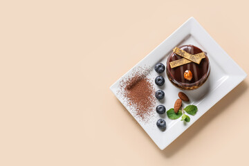 Plate with delicious chocolate cake and blueberries on light background