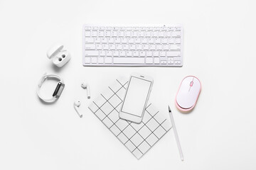 Composition with mobile phone, keyboard and modern gadgets on white background
