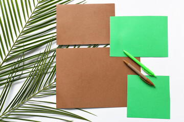 Composition with blank cards, pens and palm leaves on white background