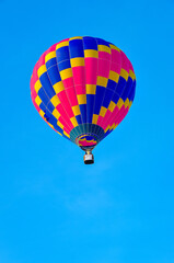 Beautiful colorful hot air balloon flying on the clear blue sky background.
