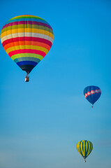 Fototapeta na wymiar Beautiful colorful hot air balloon flying on the clear blue sky background.