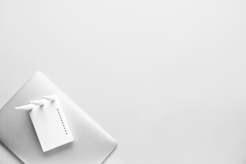 Wi-Fi router and laptop on light background