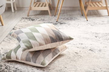 Fototapeta na wymiar Pillows on soft carpet in stylish room interior