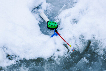 ice fishing. winter fishing. The fishing rod lies in the snow