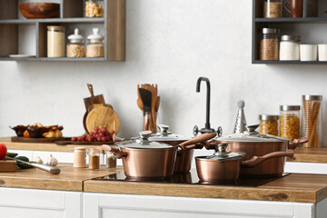 Obraz na płótnie Canvas Shiny copper cooking pots on stove in kitchen