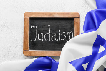 Chalkboard with word JUDAISM and flag of Israel on light background