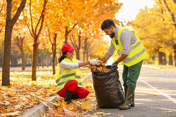 Workers gathering autumn leaves outdoors