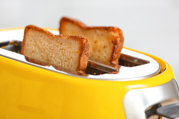 Yellow toaster with bread slices, closeup