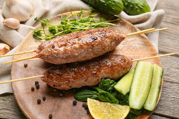 Plate of skewers with tasty lula kebab on wooden background, closeup