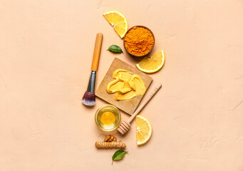 Composition with turmeric mask, powder, honey and makeup brush on beige background