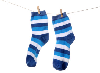 Pair of striped socks hanging on rope against white background