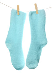 Pair of warm socks hanging on rope against white background, closeup