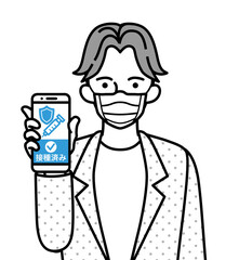ワクチン接種証明の画面を表示したスマホを持つマスクを着用した若い男性