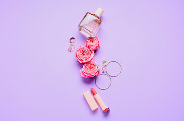 Obraz na płótnie Canvas Perfume, lipstick, accessories and flowers for International Women's Day celebration on purple background