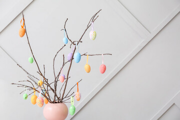 Creative composition with tree branches and Easter eggs on grey background