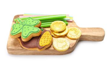 Wooden board with different sweets for St. Patrick's Day celebration on white background