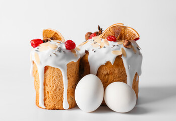 Delicious Easter cakes and eggs on light background