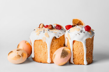 Delicious Easter cakes and eggs on light background