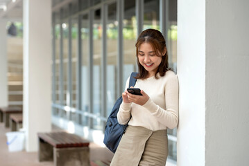 Young Asian woman enjoying playing with mobile phone.