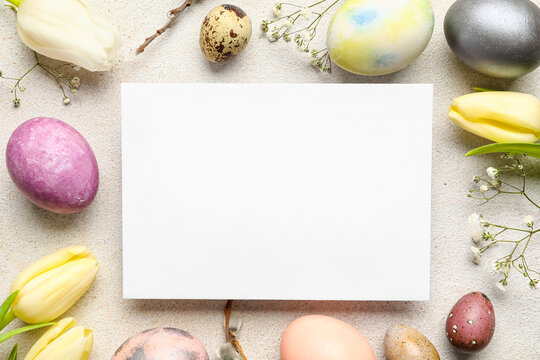 Composition with sheet of paper, Easter eggs and flowers on light background
