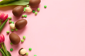 Composition with chocolate Easter eggs, different candies an flowers on pink background