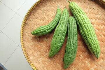 Bitter melons (Momordica charantia) on rounded woven bamboo container