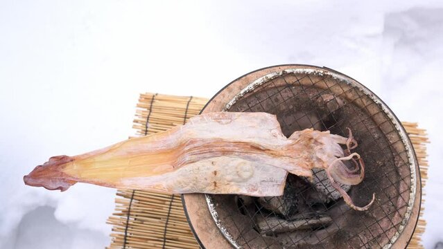 雪の中でスルメの炙り焼き