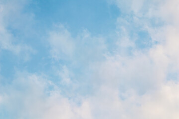Background of blue sky with white pink clouds at sunset