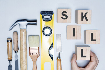 Skills concept. Word SKILL on wooden cubes and construction tools.