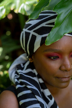 Portrait of African woman, in leaves, wearing a headscarf