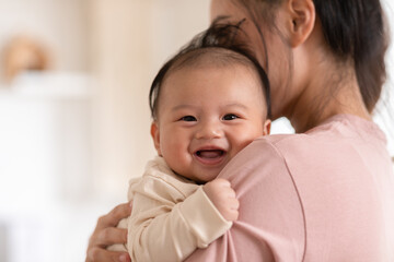 Adorable newborn baby smile and relax in mother arm safety and comfortable.Healthy Asian newborn...