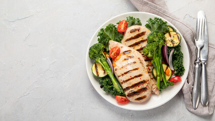 Grilled chicken with vegetables on light background.