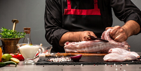 Chef cuts the carcass rabbit raw meat, using meat cleaver, Hands of a chef preparing a rabbit. Long banner format