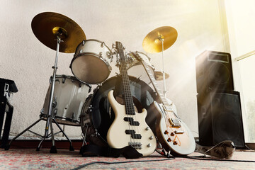 Electric guitar, bass guitar and rams in the recording studio and in the rays of bright sunlight.. Rock and roll band instruments - obrazy, fototapety, plakaty