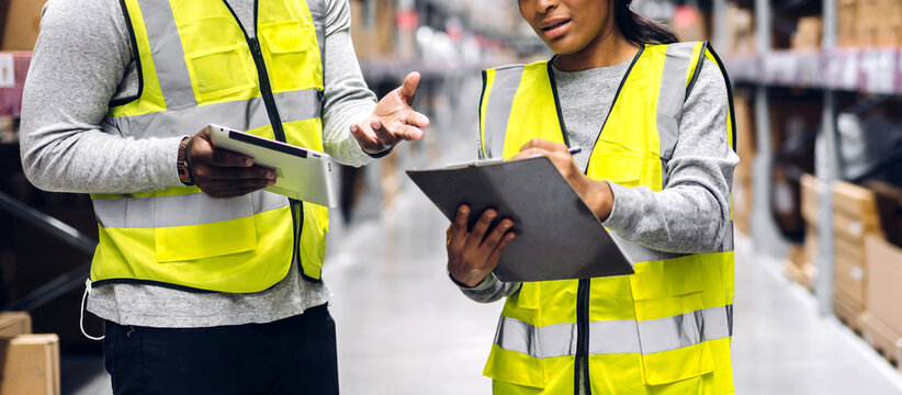 Portrait two african american engineer team shipping order detail on tablet check goods and supplies on shelves with goods inventory in factory warehouse.logistic industry and business export