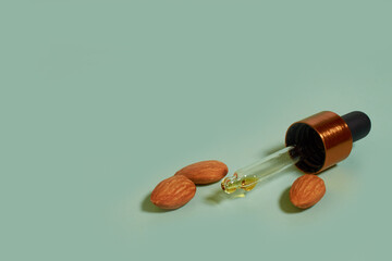 Glass pipette with almond oil and almond kernels