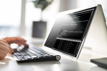 Computer Programmer Writing Program Code On Computer