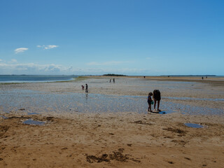 People on the low tide sand bridge between Wellington Point and King Island, Moreton Bay, Queensland, Australia 